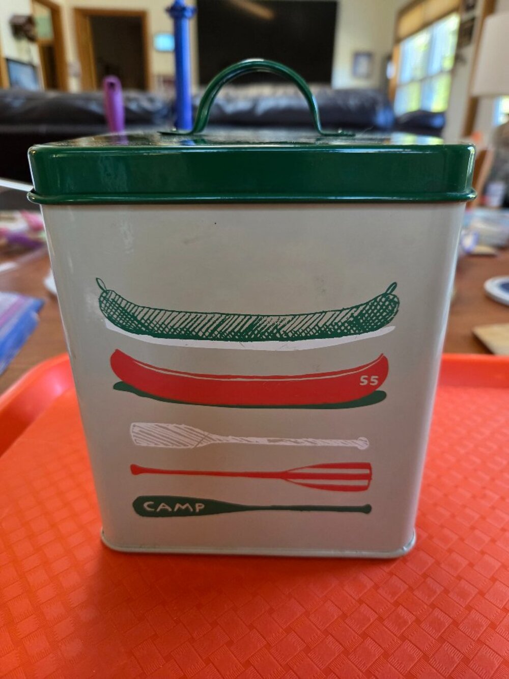decorative metal storage tin with canoe themed graphics